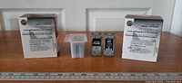 Two retail boxes, one color cartridge in blister, two black cartridges, ruler for scale