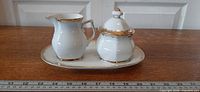 Creamer, lidded sugar bowl and tray grouped on table