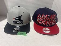 Front view of both caps showing team logos and colors