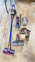 Full view of vacuum with wand attached and all accessories laid out