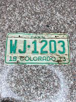 Front view of plate showing full text FARM WJ-1203 19 COLORADO 73, white background with green characters, visible wear