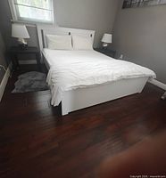 Full view of assembled white queen platform bed with headboard