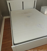 Top view of queen mattress on frame showing overall staining