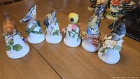 All six porcelain bird bell figurines on table