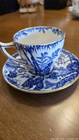Teacup on saucer showing pattern and gold trim
