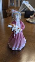 Front view of figurine showing girl, dress, puppy