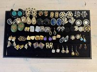 Overview of all earrings on black tray