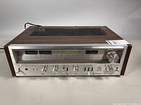 Front/side view showing overall receiver, case, controls, and power cord