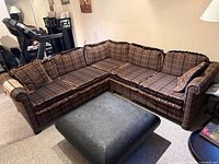 Overall view of sectional sofa showing upholstery pattern, fringe trim, and pillows