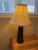 Full view of lamp on table, shade illuminated