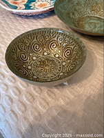 Close-up of small green-gold swirl metal bowl