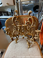 Front view of one sconce showing full ornate design and candle sockets