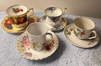 Group shot of four teacups and four saucers showing mixed patterns