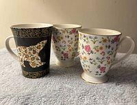 Three mugs side-by-side showing patterns, colours, relative sizes