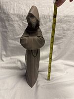 Front view of figurine with tape measure showing height
