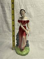 Full frontal view of figurine with tape measure showing height