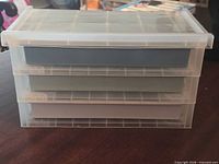 Front view showing three colored drawers inside clear housing