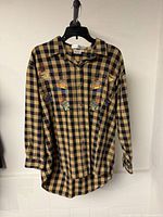 Front view of tan and navy check shirt with embroidery