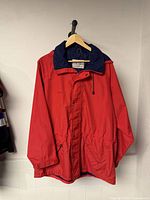 Front view of red Far West Canada hooded jacket hanging on hanger
