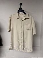Front view of off-white men’s short-sleeve button shirt on hanger