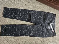 Full view of pants laid flat showing pattern and straight leg cut