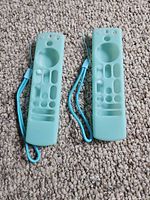 Front of two teal/turquoise silicone remote covers with lanyards