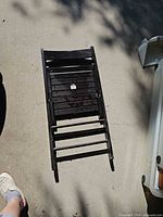 Chair folded flat on concrete showing overall condition and finish