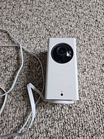 Front view of Wyze Cam Pan showing lens and attached USB cable
