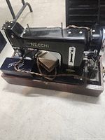 Left front view of Necchi sewing machine on wood base