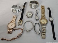 Group shot of all wristwatches and loose parts on grey surface