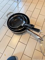 Three nested pans showing interior non-stick surfaces and handles