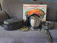 Group shot showing mixer with bowl and attachments, enamel roaster with lid, Bundt pan, trivet, coaster