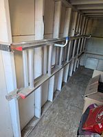 Werner aluminum extension ladder hanging on wall hooks