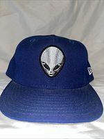 Front view of royal blue cap showing alien head embroidery
