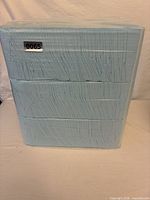Front view of sealed brick pack of blue puppy pads