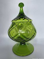 Front view of green glass pedestal candy jar with lid