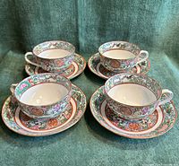 four teacups on four saucers front perspective showing pattern and colours