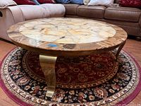 Full view of round stone-top coffee table on rug