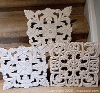 Front view of three white carved wood panels on stairs