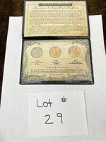 Full view of closed display showing three coins and COA