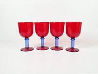 Front view of all four red and blue plastic goblets standing in a row