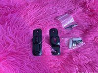 Latch and keeper pieces with hardware bags on pink background