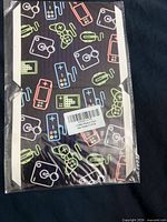Front view of sealed package showing neon gaming icon patterned sleeves