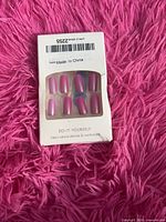 Front of package showing pink and purple press-on nails