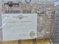 Overall view of newspaper in protective sleeve on stand with COA visible