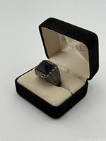 Ring in presentation box, side profile showing stone and accents
