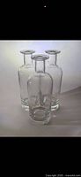Three clear glass bottles standing upright