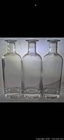 Front view of three identical clear glass decanters