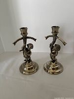Front view of both silver-plated putti candleholders