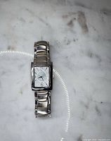 Full wristwatch laid flat on marble showing overall design
